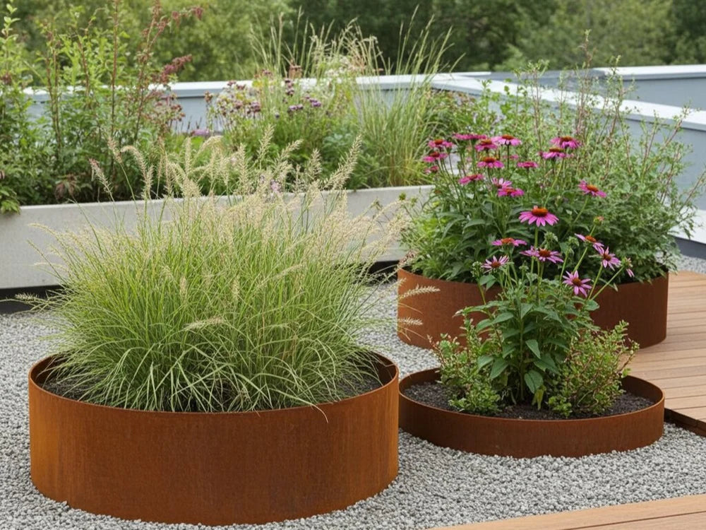 Beeteinfassung aus Cortenstahl mit Ziergräsern und Blumen neben Terrasse