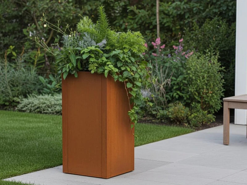 Hoher CUBY Pflanzkasten aus Cortenstahl mit Pflanzen im Garten