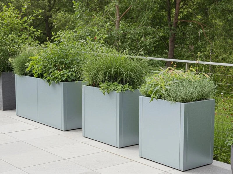 Mehrere Pflanzkästen aus verzinktem Stahl von CUBY mit Ziergräsern