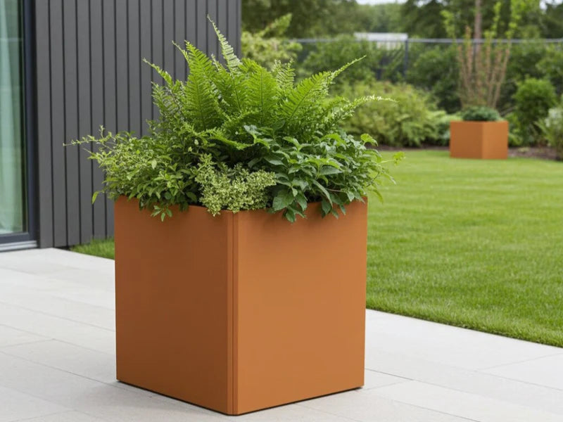 EDGY Pflanzkübel aus Cortenstahl in hoher quadratischer Form im Garten