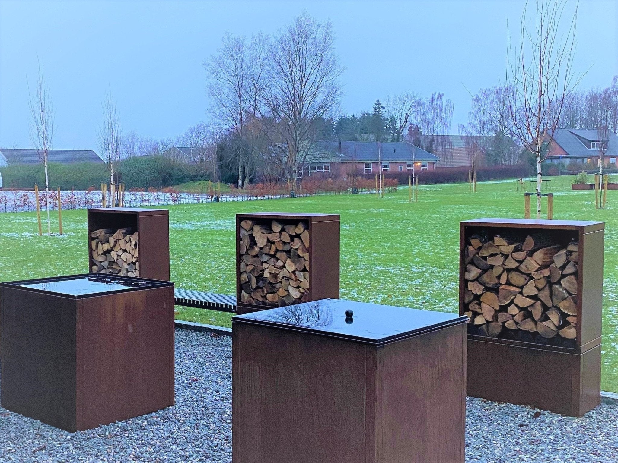 Modulares Holzlager aus Cortenstahl mit Sitzbank und Outdoor-Modulen im Garten