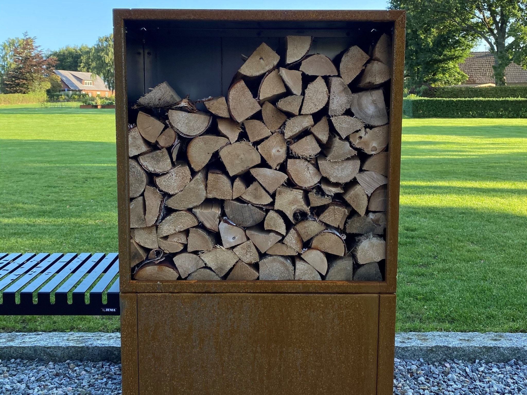 Frontansicht eines Kaminholzregals aus Cortenstahl im Garten