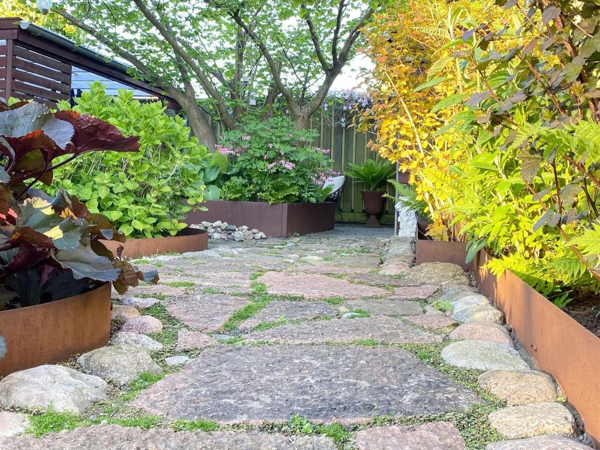 Beeteinfassung aus Cortenstahl entlang eines Gartenwegs – moderne und langlebige Beetkante aus Metall