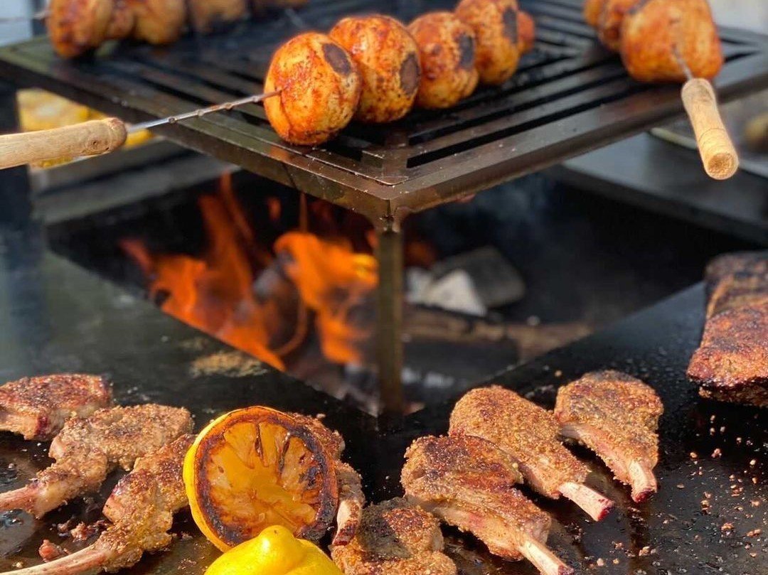 byJEMA Feuerstelle aus Cortenstahl – Lammkoteletts, gegrillte Zitrone und Spieße über offenem Feuer