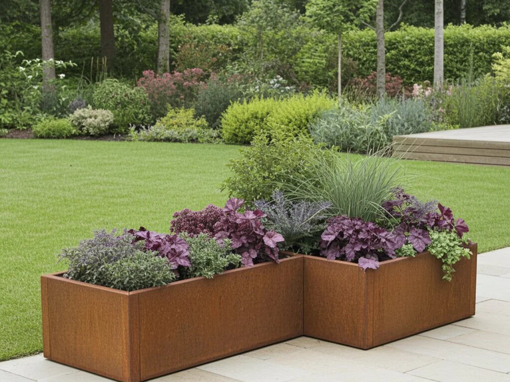byJEMA L-förmiger Pflanzkübel aus Cortenstahl mit Zierpflanzen im modernen Garten