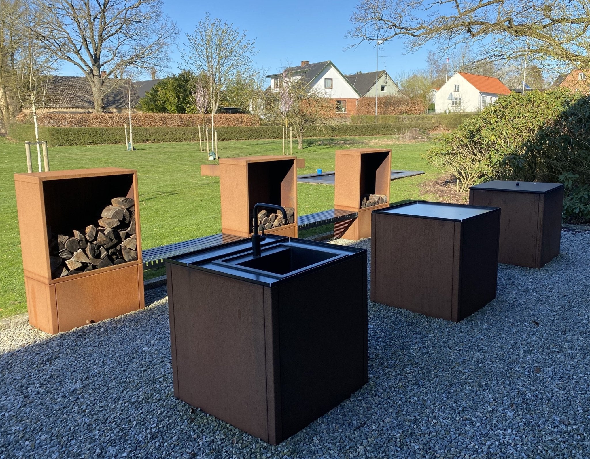 Outdoor Küche aus Cortenstahl mit integriertem Holzlager und Sitzbank