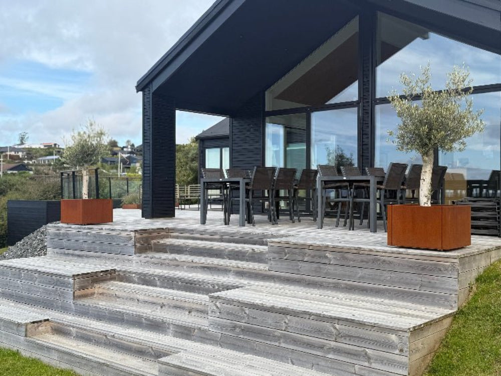 Mehrere CUBY Pflanzkästen aus Cortenstahl auf Terrasse