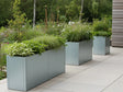 Pflanzkästen aus verzinktem Stahl von CUBY mit Stauden entlang Terrasse
