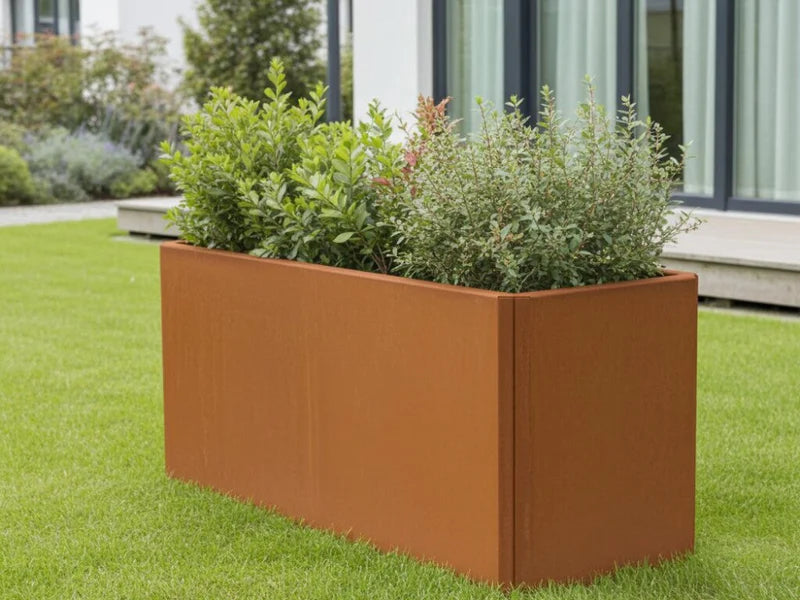 Rechteckiger EDGY Pflanzkübel aus Cortenstahl mit grüner Bepflanzung im Garten