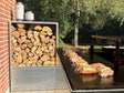 Kaminholzregal aus verzinktem Stahl kombiniert mit Outdoor-Küche im Garten