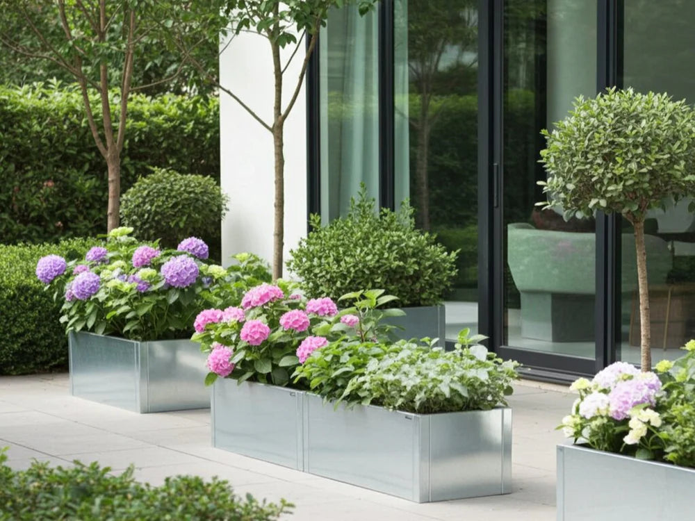Langer Pflanzkübel aus verzinktem Stahl mit Blumen und Sträuchern auf der Terrasse
