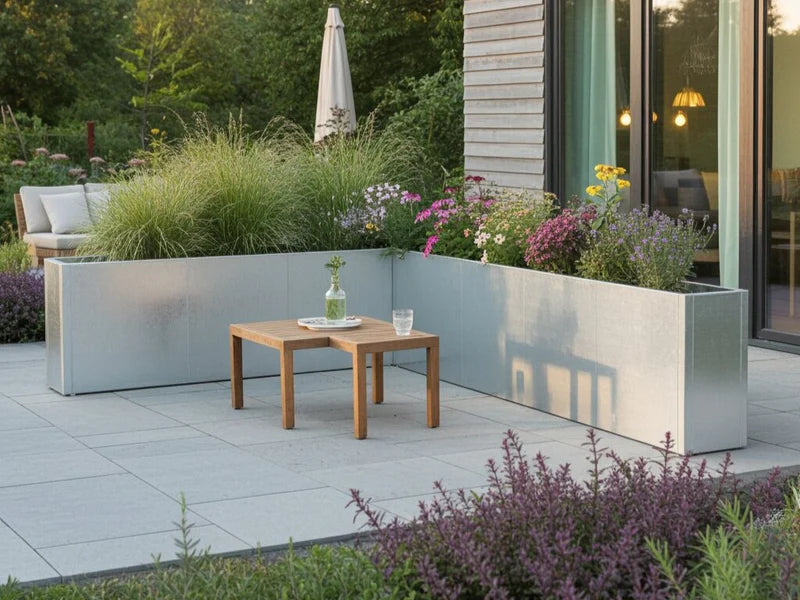 Eckförmiges Hochbeet aus verzinktem Metall mit Ziergräsern und Stauden